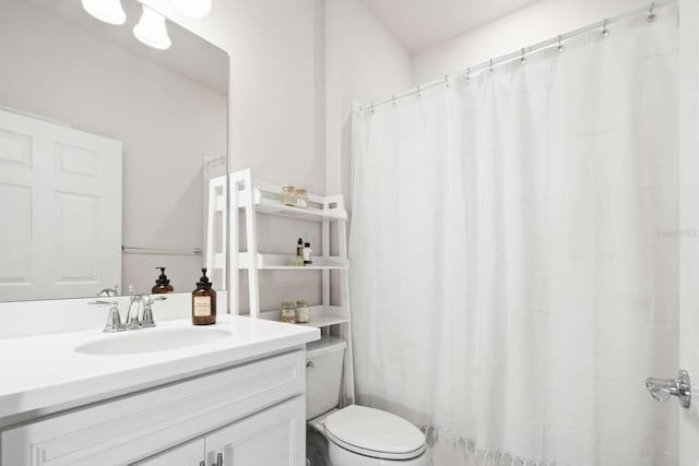 bathroom featuring curtained shower, vanity, and toilet