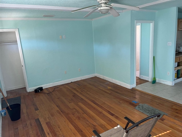 spare room featuring wood-type flooring, a textured ceiling, ceiling fan, and crown molding