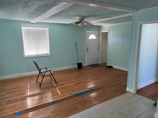 entryway featuring beamed ceiling, a textured ceiling, light hardwood / wood-style flooring, and ceiling fan