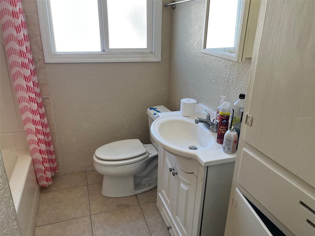 full bathroom with tile patterned floors, a wealth of natural light, vanity, and toilet