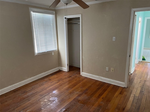 unfurnished bedroom featuring hardwood / wood-style flooring, ceiling fan, ornamental molding, and a closet