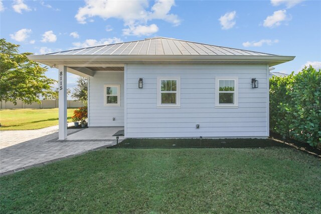 rear view of property with a lawn and a patio area