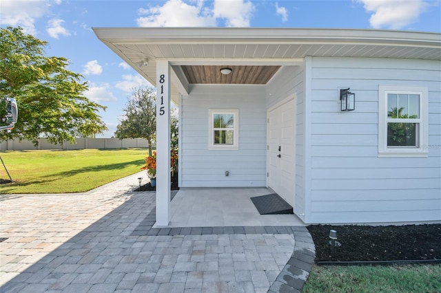 entrance to property with a yard and a patio