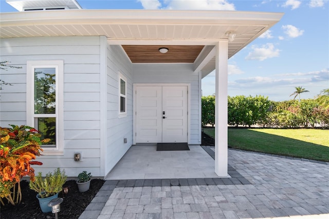 property entrance featuring a lawn