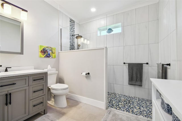 bathroom with a tile shower, tile patterned flooring, vanity, and toilet