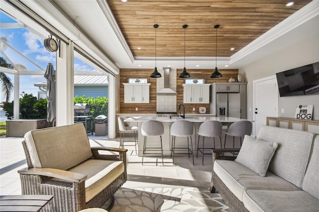 interior space featuring a raised ceiling, wooden ceiling, and sink