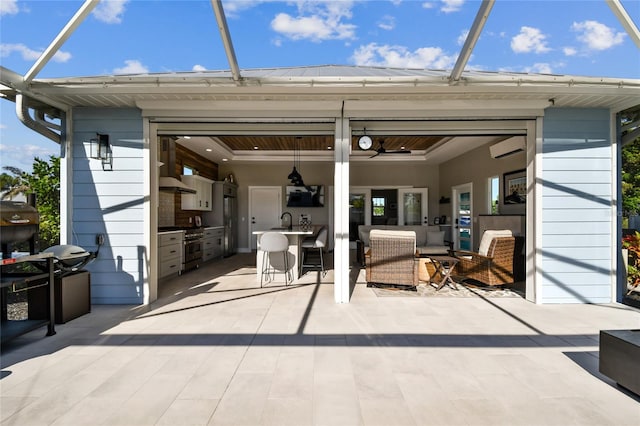 view of patio / terrace with ceiling fan, area for grilling, a lanai, and a wall unit AC