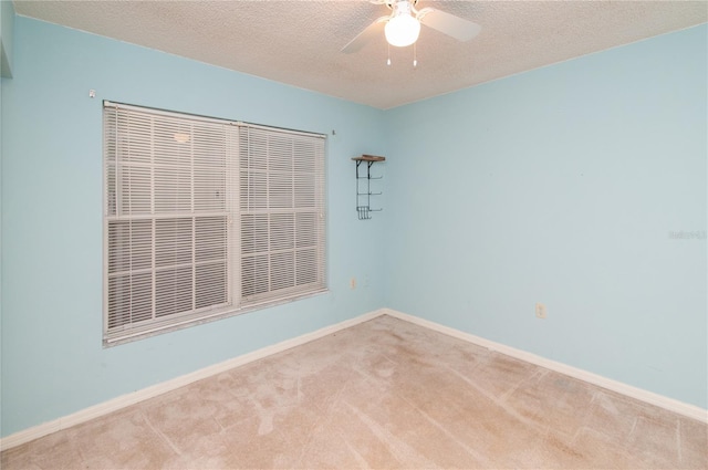 carpeted spare room with ceiling fan and a textured ceiling