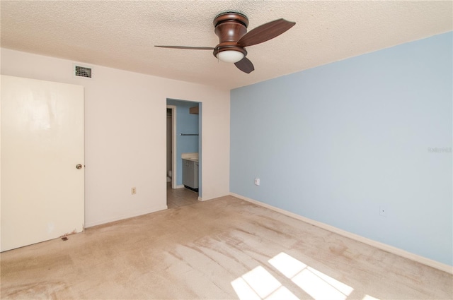 unfurnished bedroom featuring a textured ceiling, ceiling fan, light carpet, and connected bathroom