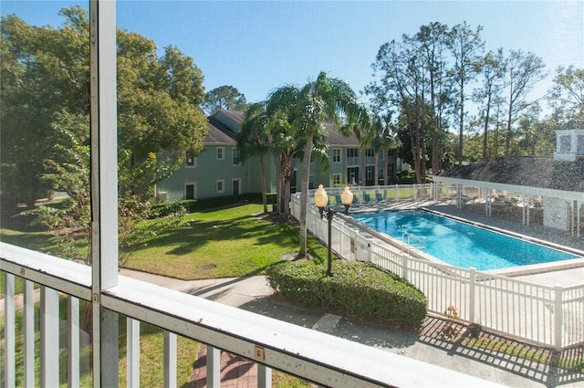 view of swimming pool with a lawn