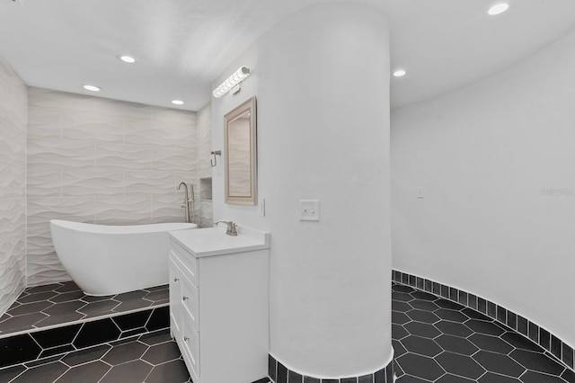 bathroom featuring tile patterned floors, a bathing tub, and vanity