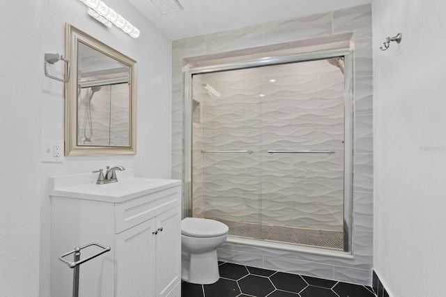 bathroom featuring tile patterned floors, vanity, toilet, and an enclosed shower