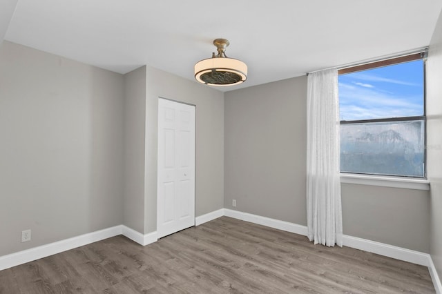 unfurnished bedroom featuring a closet and hardwood / wood-style floors