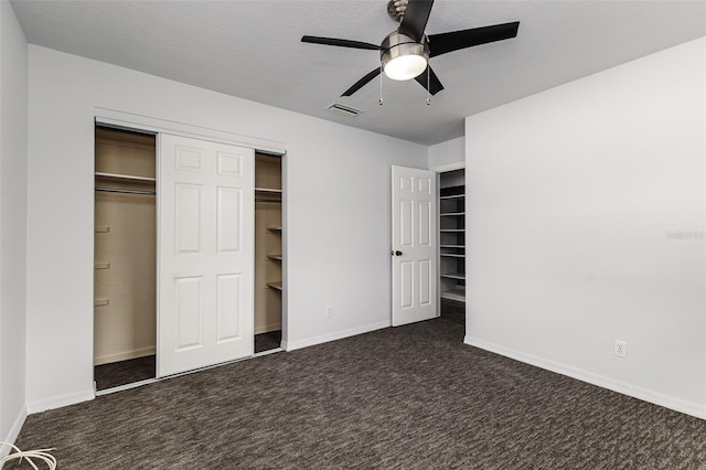 unfurnished bedroom featuring ceiling fan and dark colored carpet