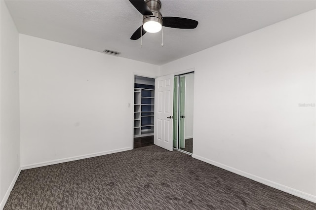 interior space featuring ceiling fan and dark colored carpet