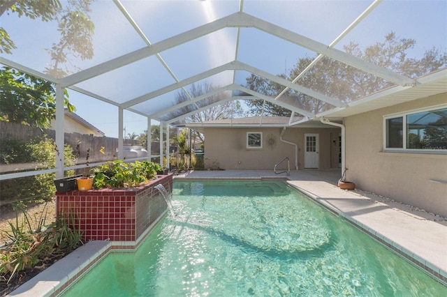 view of pool featuring pool water feature, a lanai, and a patio