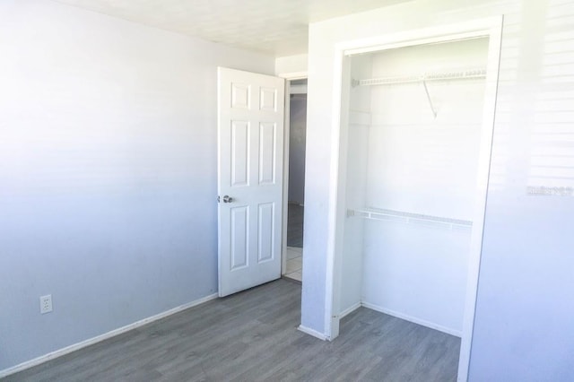 unfurnished bedroom featuring dark hardwood / wood-style floors and a closet