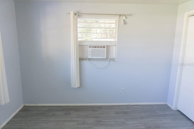 unfurnished room featuring cooling unit and dark wood-type flooring