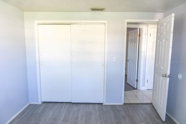 unfurnished bedroom featuring hardwood / wood-style flooring and a closet