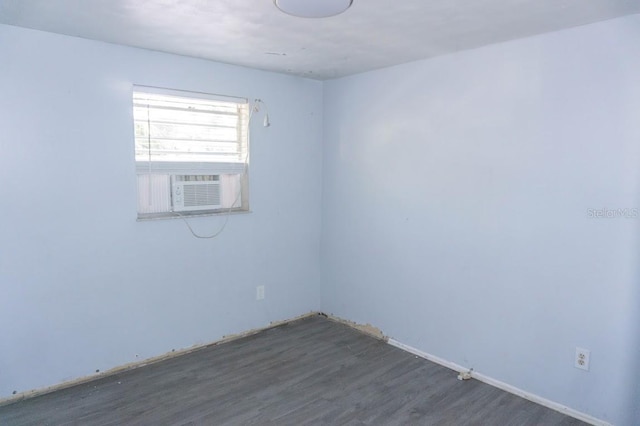 spare room featuring cooling unit and dark hardwood / wood-style flooring