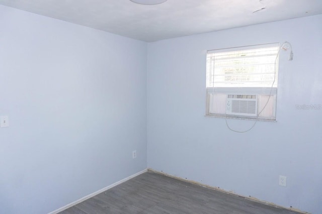 unfurnished room featuring hardwood / wood-style floors and cooling unit