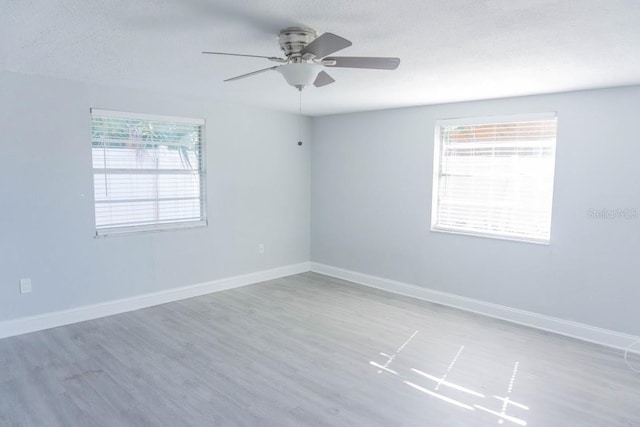 unfurnished room featuring hardwood / wood-style floors, ceiling fan, and a textured ceiling