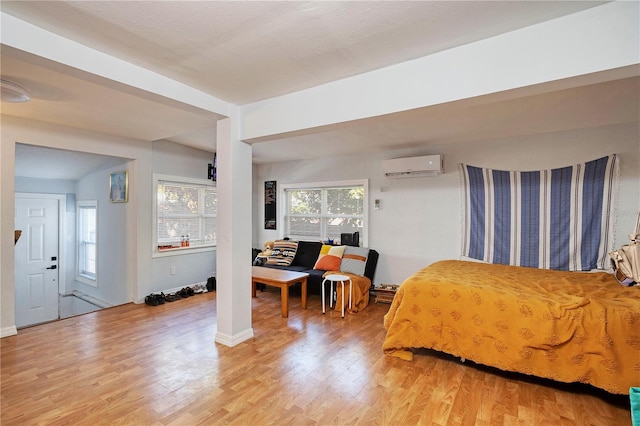 bedroom with an AC wall unit and hardwood / wood-style floors