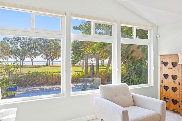 living area with a water view, plenty of natural light, and lofted ceiling