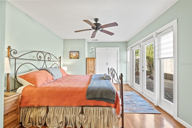 bedroom with access to exterior, hardwood / wood-style floors, french doors, and ceiling fan