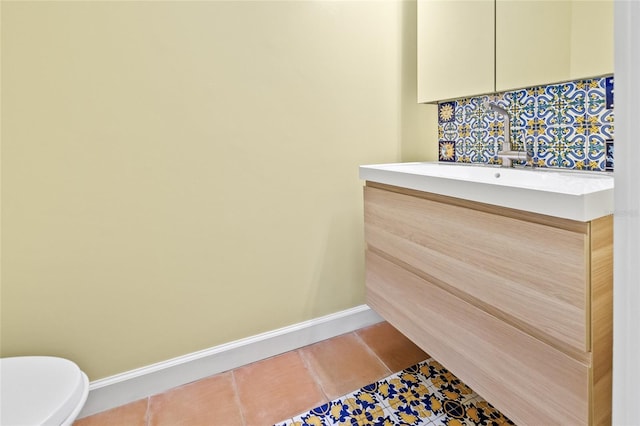 bathroom with toilet, vanity, and tile patterned floors