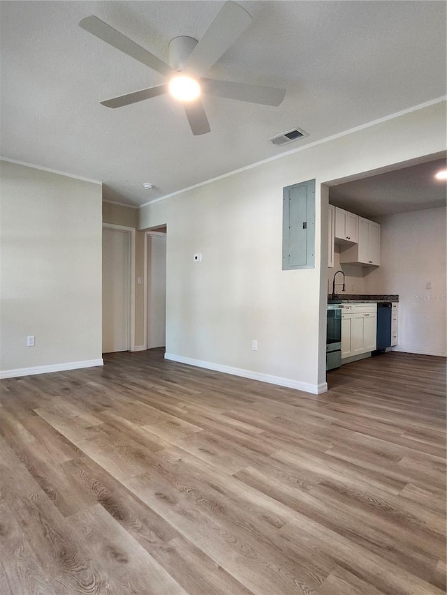 unfurnished living room with light wood-type flooring, a textured ceiling, ceiling fan, crown molding, and electric panel