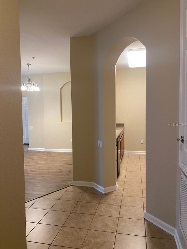 hallway with light hardwood / wood-style floors and a notable chandelier