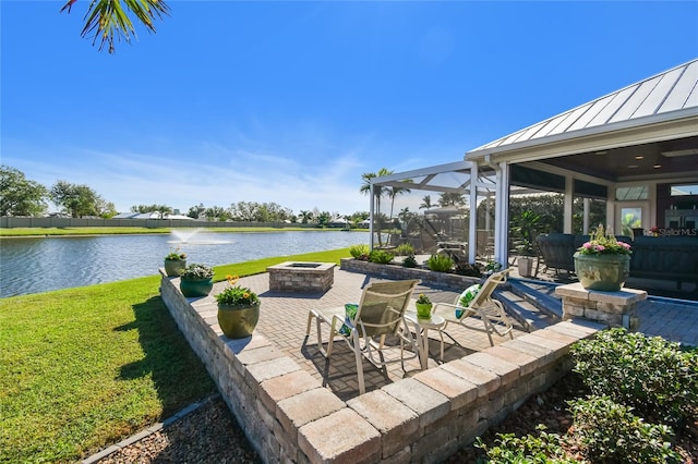 view of patio / terrace featuring a lanai, a water view, and a fire pit