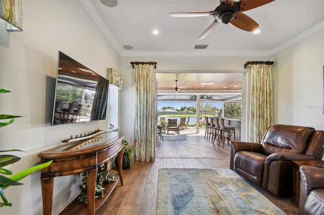 living room with ceiling fan, crown molding, and wood-type flooring