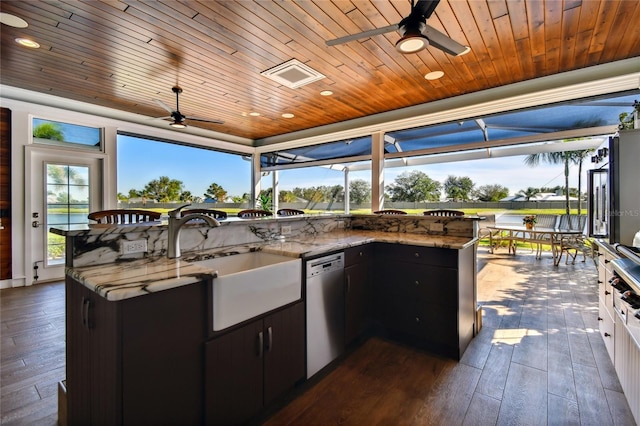 view of patio / terrace with an outdoor kitchen, ceiling fan, a water view, and sink