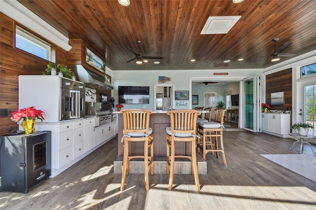 kitchen with dark hardwood / wood-style floors, white cabinetry, wooden walls, and wooden ceiling