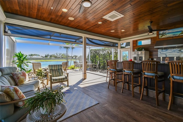 sunroom featuring a water view and wood ceiling