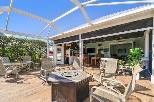 view of patio with exterior bar, ceiling fan, and a lanai