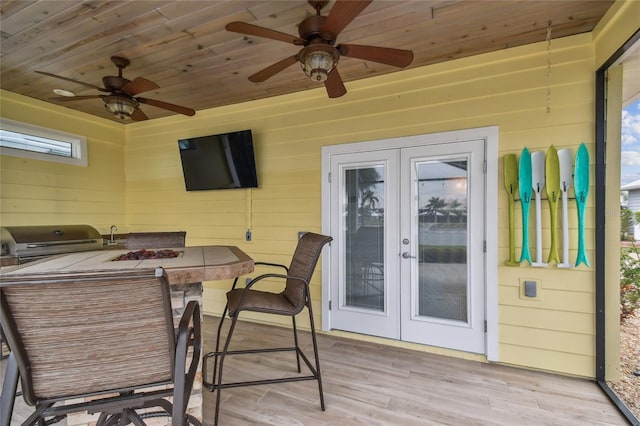 sunroom featuring french doors, ceiling fan, and wooden ceiling