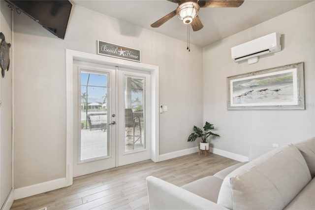 living area featuring ceiling fan, light hardwood / wood-style flooring, a wall unit AC, and french doors