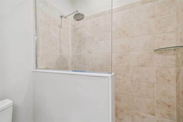 bathroom featuring toilet and a tile shower