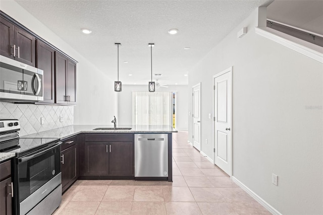 kitchen with kitchen peninsula, backsplash, stainless steel appliances, sink, and pendant lighting