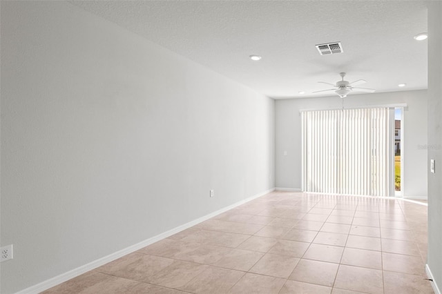 tiled empty room featuring ceiling fan and a textured ceiling