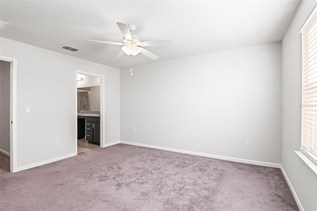 unfurnished bedroom with carpet flooring, multiple windows, and ceiling fan