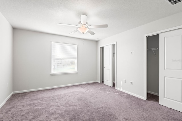 unfurnished bedroom with carpet flooring, ceiling fan, and a textured ceiling