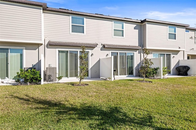 rear view of property with a yard and central air condition unit