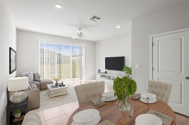 living room with light tile patterned floors, a textured ceiling, and ceiling fan