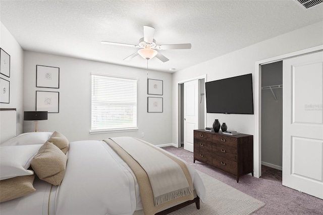 carpeted bedroom with a textured ceiling and ceiling fan