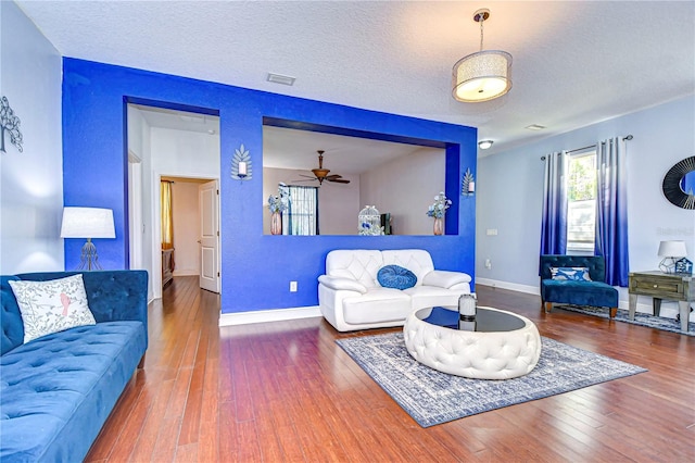 living room featuring hardwood / wood-style floors, a textured ceiling, and ceiling fan