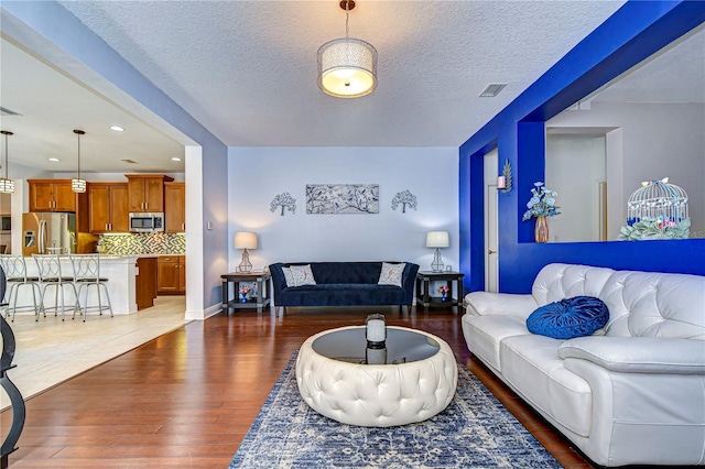 living room featuring a textured ceiling and dark hardwood / wood-style floors